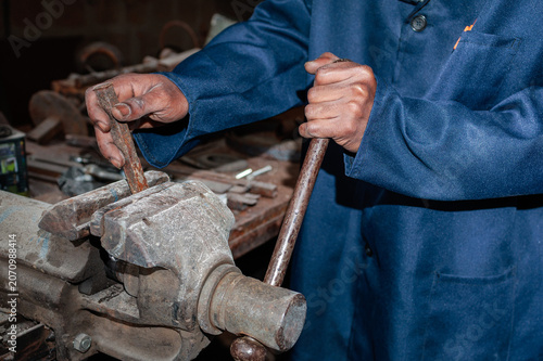 Worker using a large metal vice