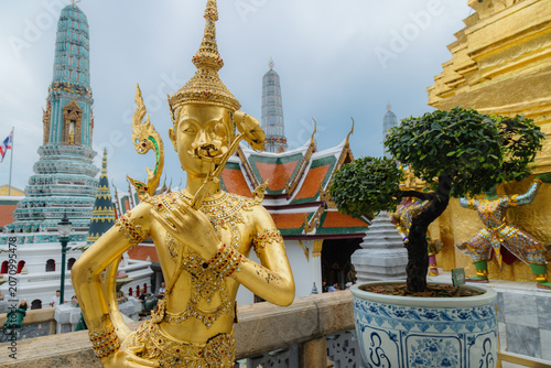Картината върху платно A golden statue of a mythical being holding a lotus flower at the Grand Palace in Bangkok, Thailand