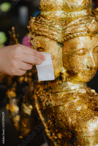 Fotografie BANGKOK, THAILAND, 5 October 2025 – A devotee applies gold leaf to a Buddha statue at Wat Phra, a temple in Bangkok, Thailand