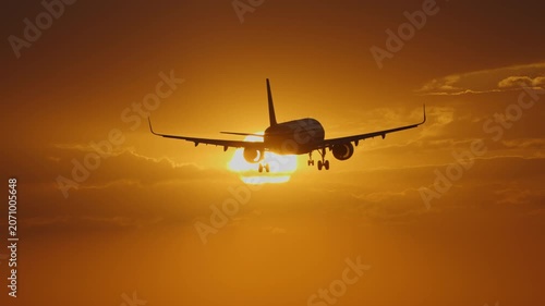 Airplane landing against a vibrant sunset with dramatic clouds