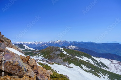 初夏の北アルプスと広大な青空 乗鞍岳から望む残雪の山並みと雄大な大自然の絶景