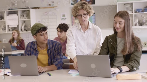 Teacher assisting student during computer class