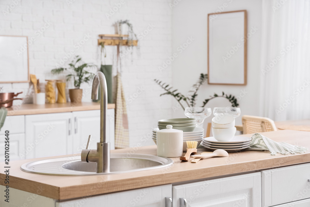 Fototapeta premium Modern kitchen countertop with clean dishes and sink