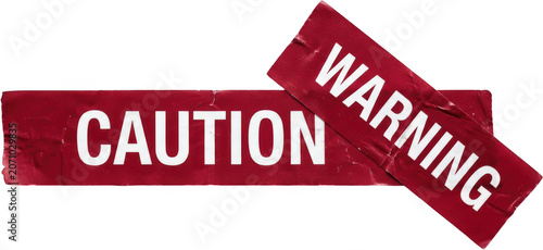Two red adhesive tapes with white lettering one reading CAUTION and the other WARNING are affixed to a surface suggesting a notice or restriction sign label text danger alert