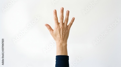 Woman's Hand Raised, Five Fingers Showing, Against White Background