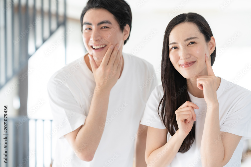 Obraz premium リビングでスキンケアをするミドルの夫婦