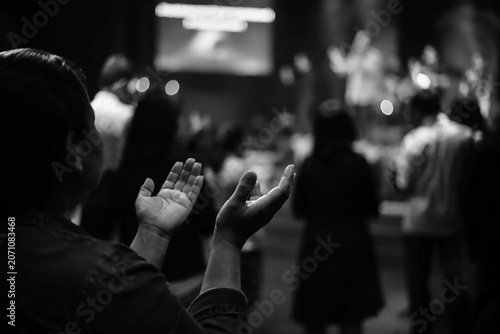 Black and white hands worship during church service