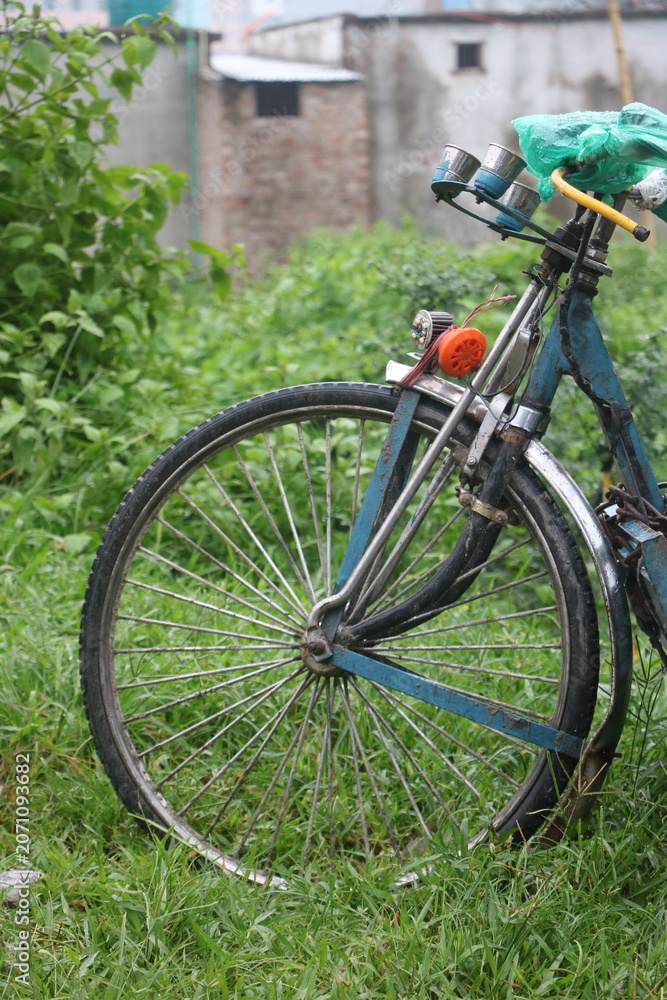 Fototapeta premium Close up of bicycle front wheel and handlebars in grass with handlebar, close
