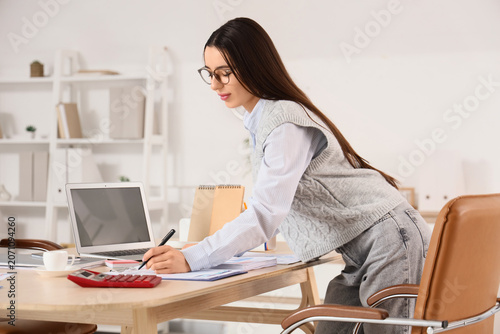 Young businesswoman writing...