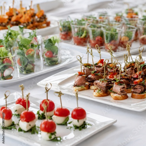 Professional catering trays with small savory bites and salad cups