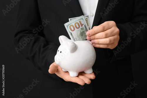 Businessman putting money i...