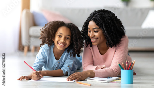Mother and daughter drawing together on the floor, happy family bonding, creative activity at home, learning and development