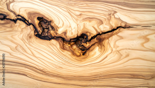 Natural wood grain texture with a dark crack and knot, showing organic patterns and rustic charm, ideal for backgrounds or natural design