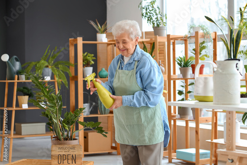 Senior florist watering pla...