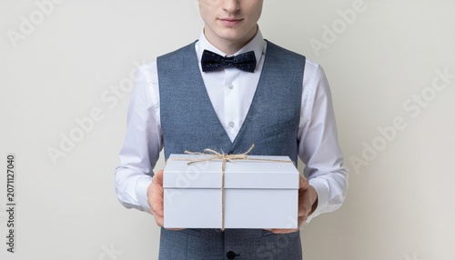 Sophisticated man presenting a neatly wrapped gift box, conveying generosity