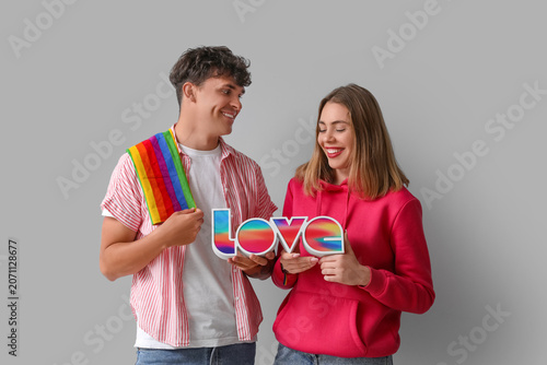 Young couple with LGBT flag...