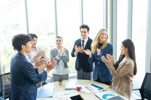 Group of diverse business people celebrating success with raised hands in the office