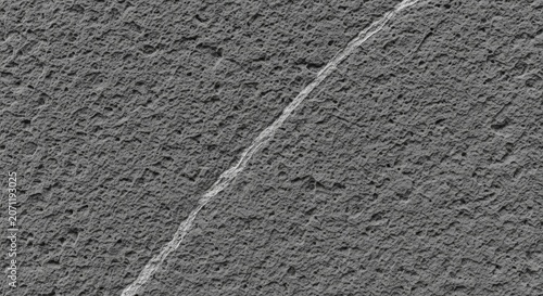 High resolution texture shot of a raw volcanic basalt slab with porous surface and a diagonal mineral vein