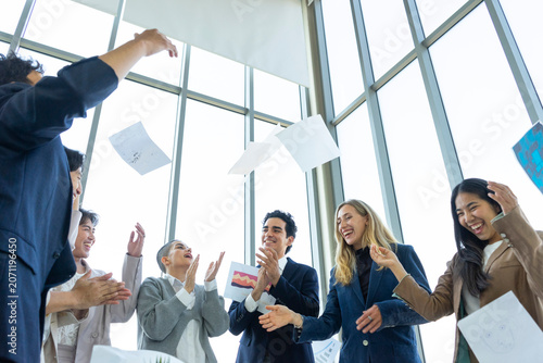 Group of diverse business people celebrating success with raised hands in the office