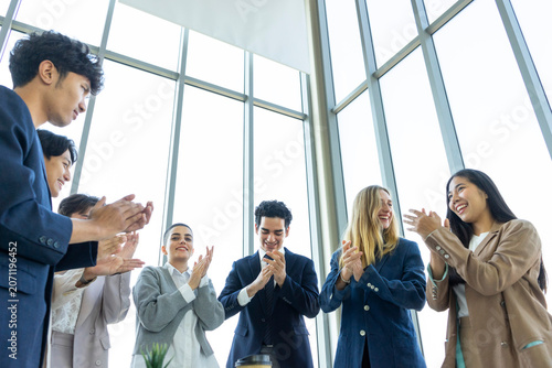 Group of diverse business people celebrating success with raised hands in the office