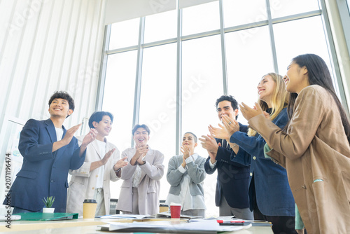 Group of diverse business people celebrating success with raised hands in the office
