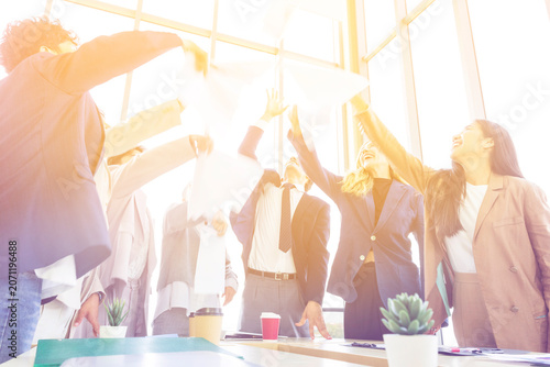 Group of diverse business people celebrating success with raised hands in the office