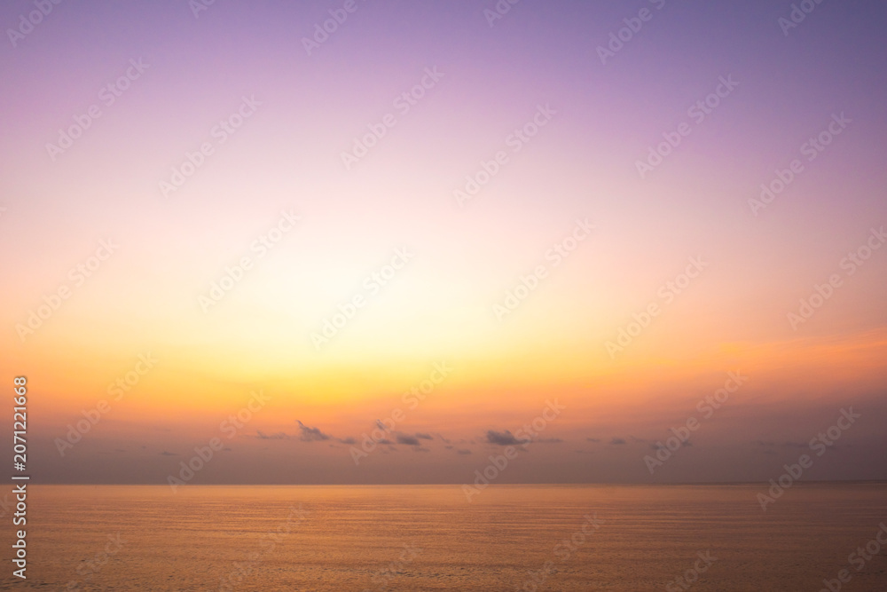 Fototapeta premium nature sky breathtaking golden sunset over a calm ocean, with the entire sky and water bathed in brilliant shades of yellow and orange. Streaky clouds enhance the dramatic display