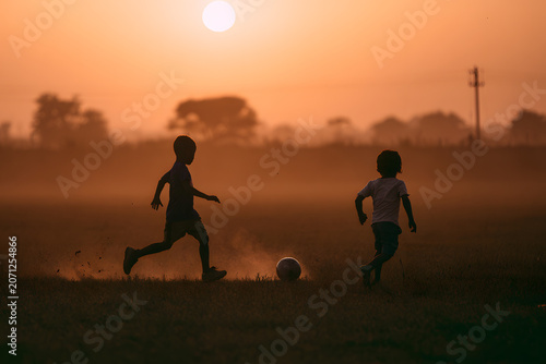 boys playing soccer in field.