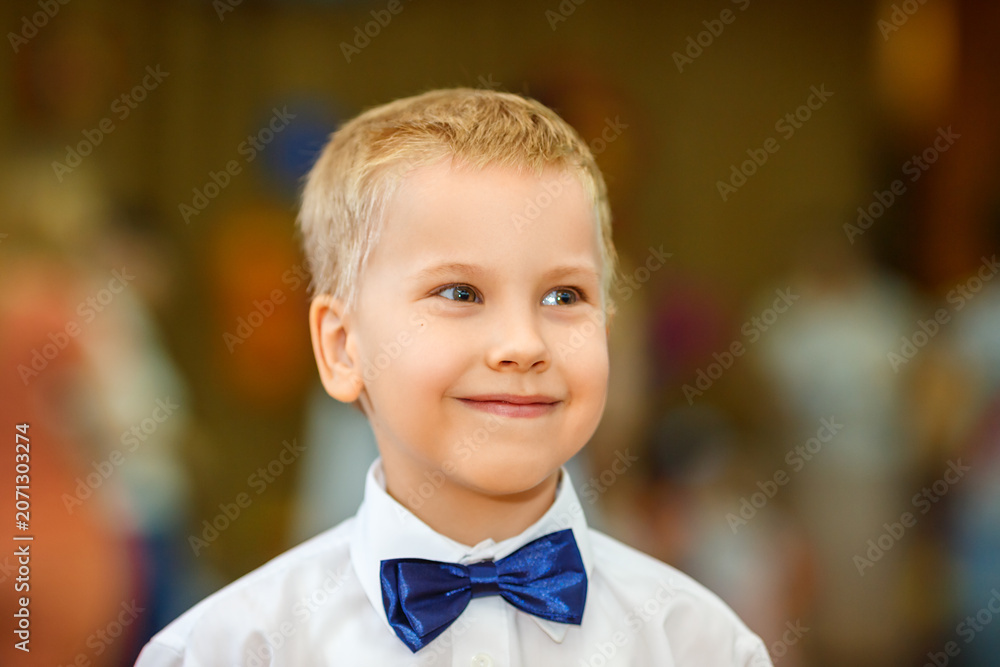 Αυτοκόλλητο Elegant Blonde Boy in Blue Bow Tie Warm Toned Formal Portrait