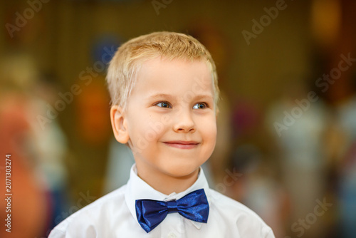 Konstfotografi Elegant Blonde Boy in Blue Bow Tie Warm Toned Formal Portrait