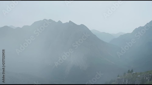 The video captures a sequence of mountain landscape scenes shrouded in mist, creating a dreamy and mysterious atmosphere
