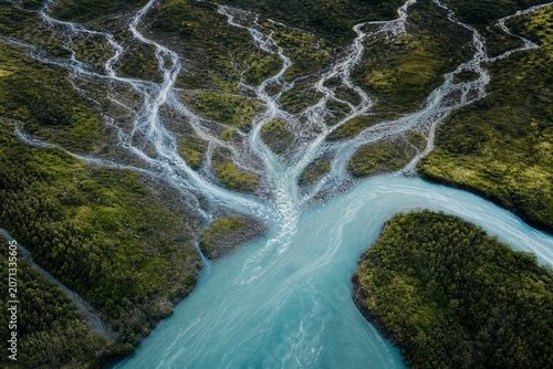 Multiple small streams merging into a single wide river viewed from above, showing water flow patterns.
