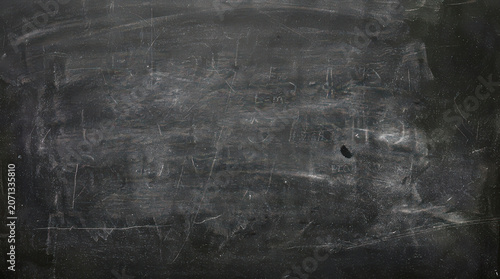 Scratched and worn blackboard surface with white marks and scratches