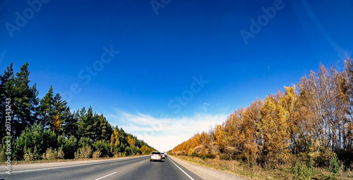 view of the autumn road from the windshield of a suburban car