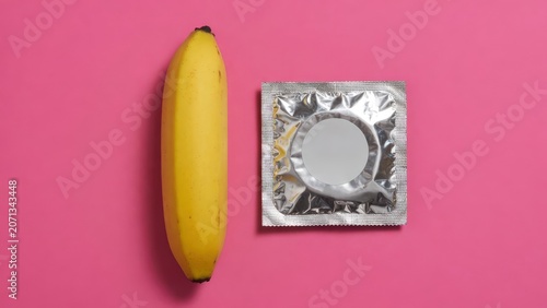 Condom and Banana On Pink Background Symbolizing Safe Sex, Contraception and Sexual Health Education