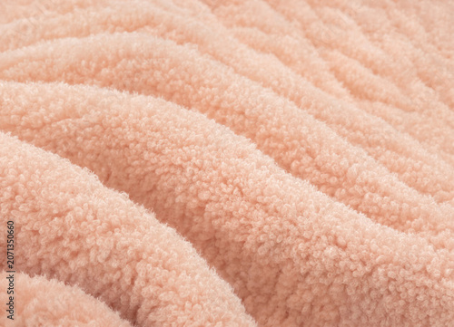 Close-up view of a fuzzy peach-colored fabric with wavy texture