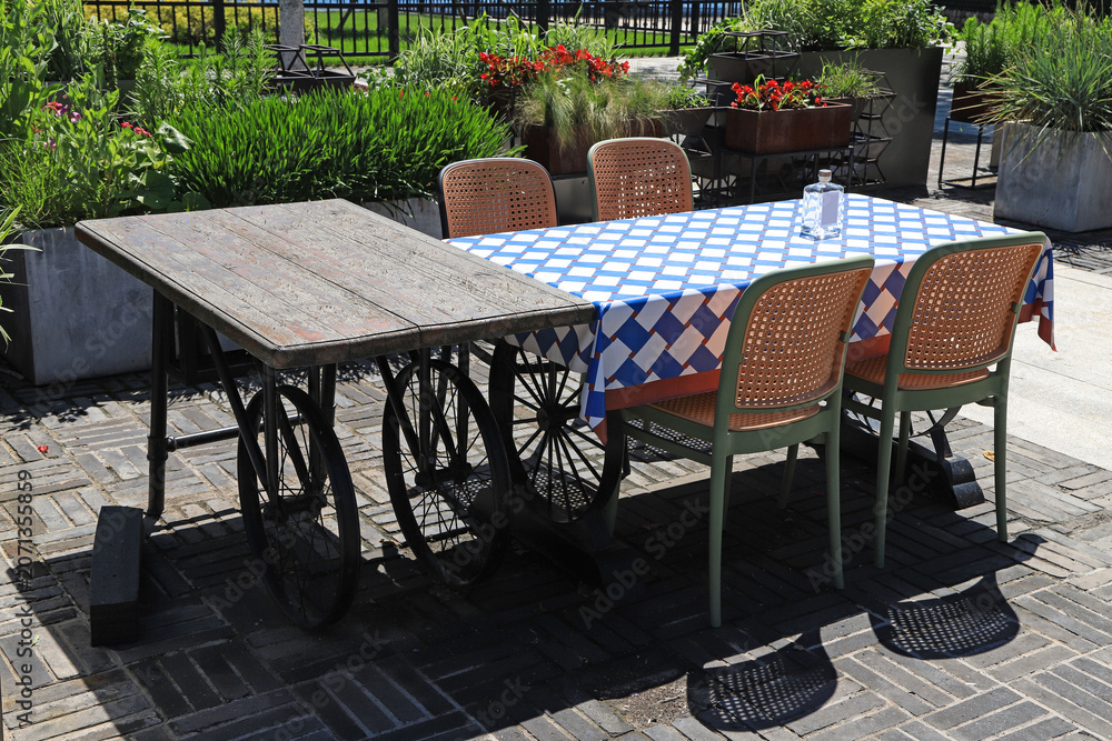 Obraz premium Outdoor leisure dining set with vintage wheel table in garden courtyard
