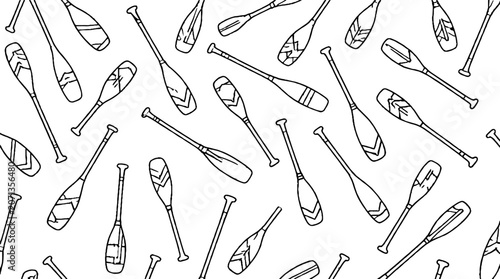 Collection of various wooden canoe paddles arranged in pattern.