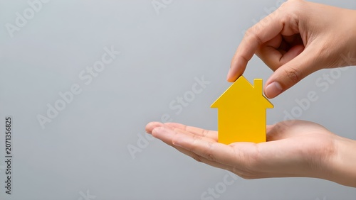 Two Hands Holding Yellow House Model Protection Real Estate Property Ownership Photo
