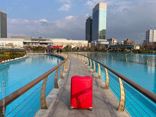 Red suitcase on modern bridge in tashkent city