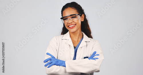 Obraz na płótnie Scientist, portrait of woman in studio with crossed arms, lab coat and ppe for medical research