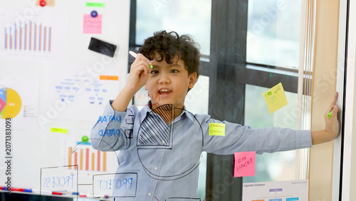 Canvas Print Young Boy Roleplaying as Businessman Drawing Charts on Transparent Glass Board