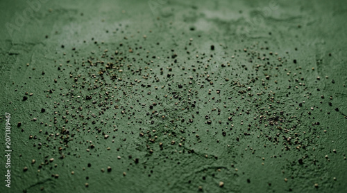 Black Pepper Sprinkled on Dark Green Background