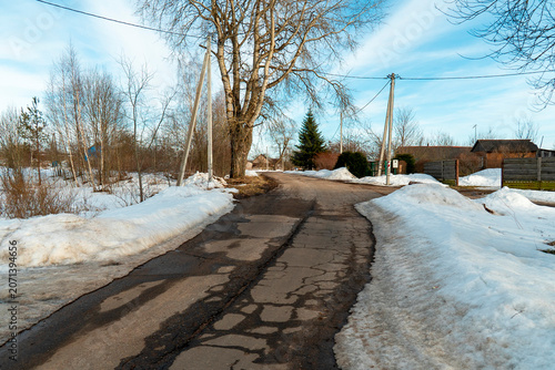 Road with snow on both sides in a rural area during daytime in early spring