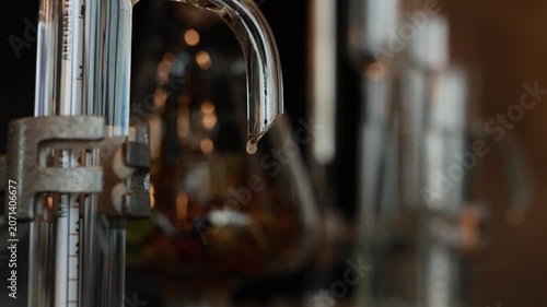 Distillation alcohol gin glass equipment laboratory liquid closeup transparent process scientific chemistry beverage industry apparatus tube macro reflection modern technology clean precise