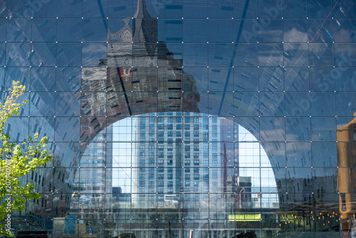 Reflective glass arch roof of Markthal Rotterdam with city reflections, sunny day, Netherlands