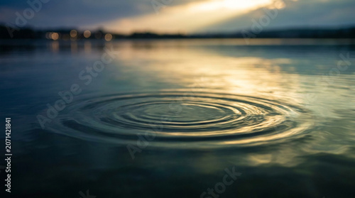 Ripples on a serene lake surface at dusk