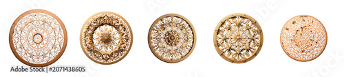 A circular, intricately carved wooden mandala is presented against a stark transparent background