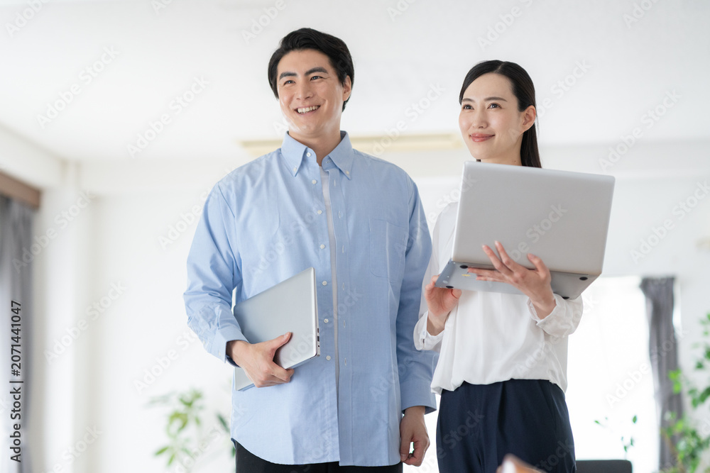 Fototapeta premium リビングでパソコンを見るミドルの夫婦