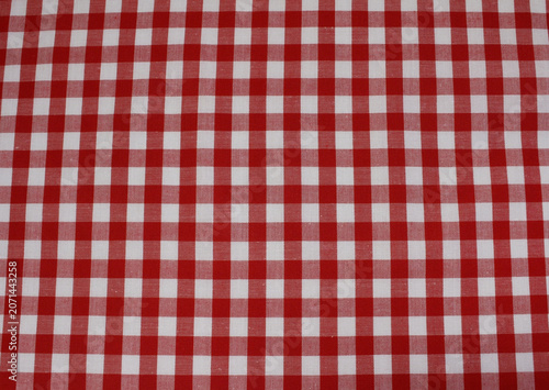 Texture of classic red checkered cotton cloth background. Close up of red and white gingham fabric.